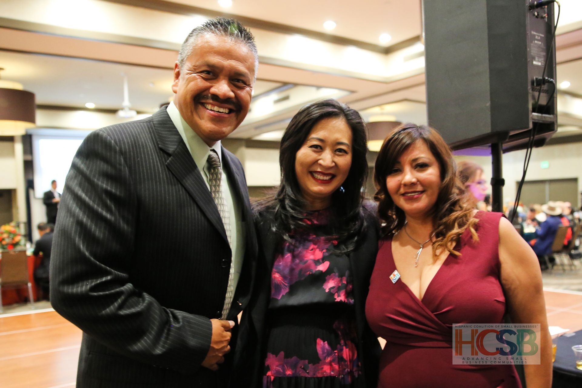 A man in a suit and tie is posing for a picture with two women.