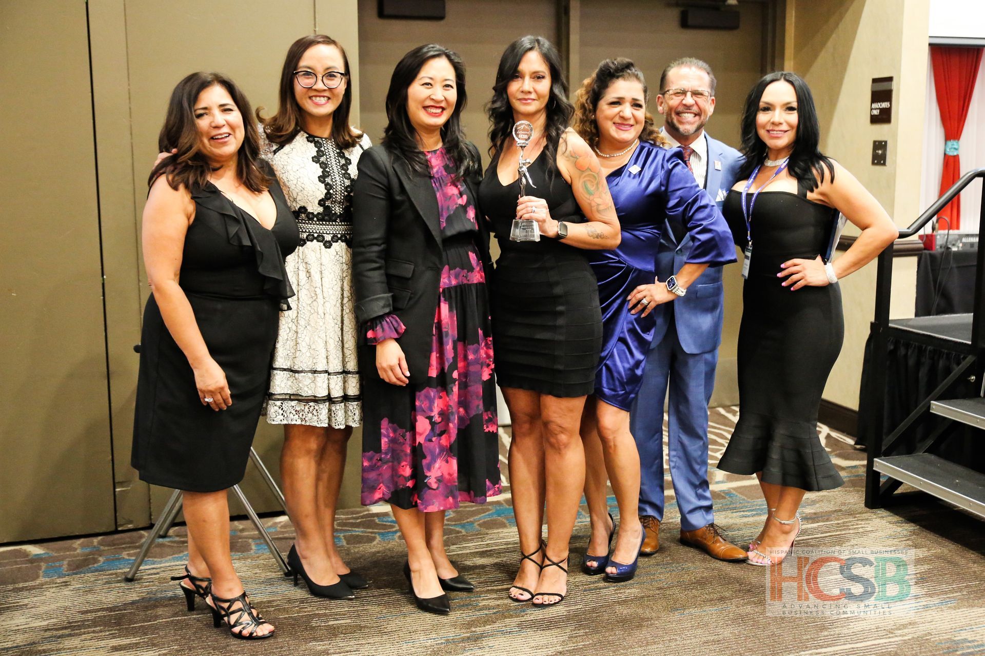 A group of women and men are posing for a picture together.
