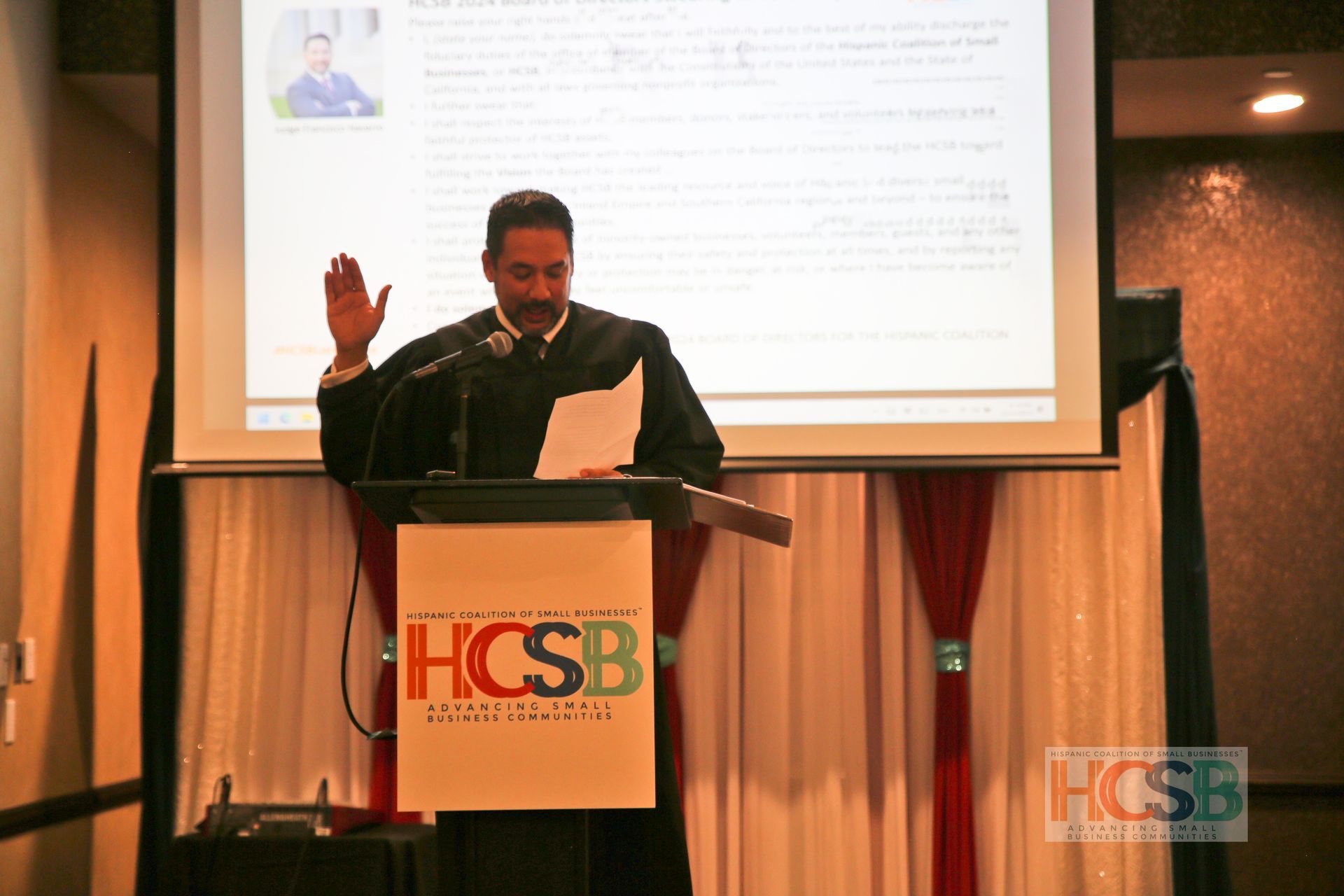 A man stands at a podium that says hcsb on it