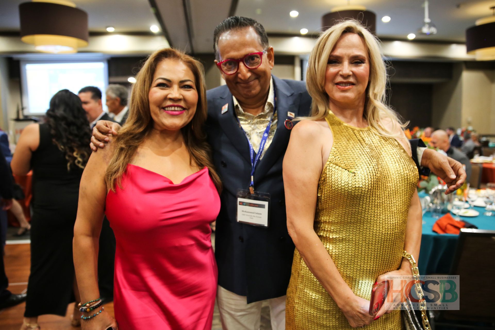 A man and two women are posing for a picture at a party.