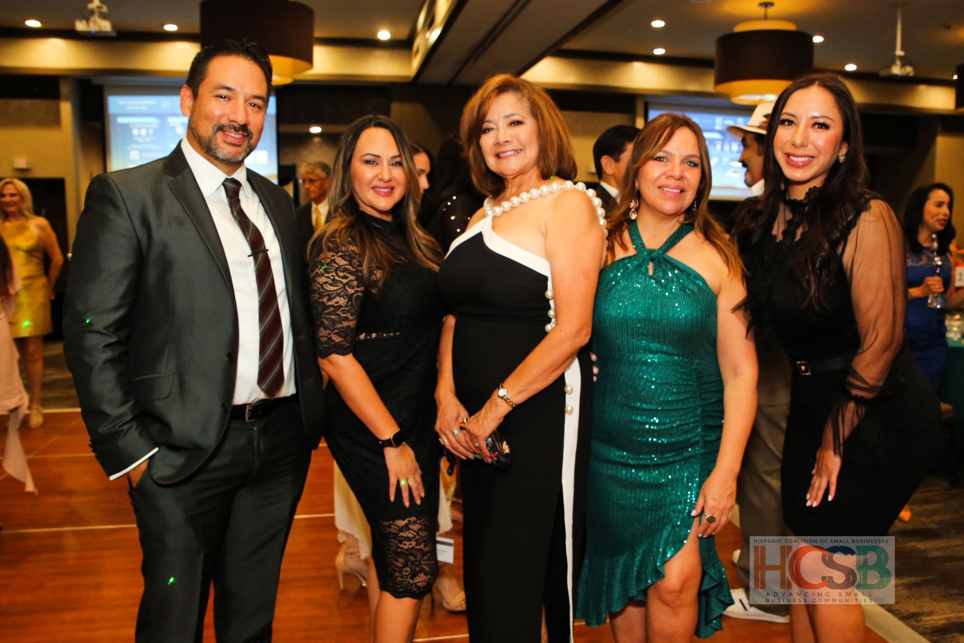 A group of people posing for a picture with a hcsb logo in the background