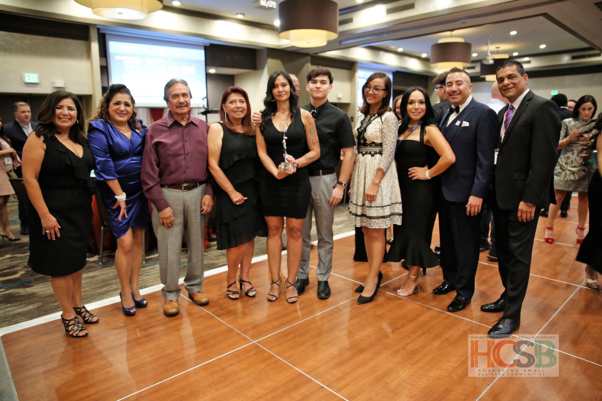 A group of people are posing for a picture on a wooden floor.