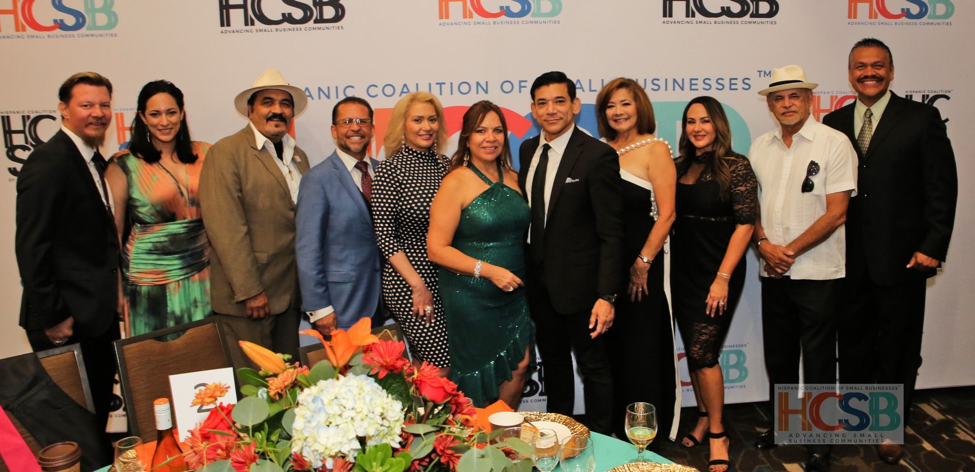 A group of people standing around a table with flowers.