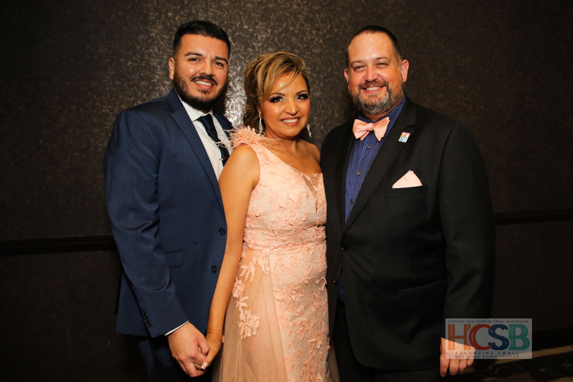 A man in a suit and tie is standing next to a woman in a pink dress.