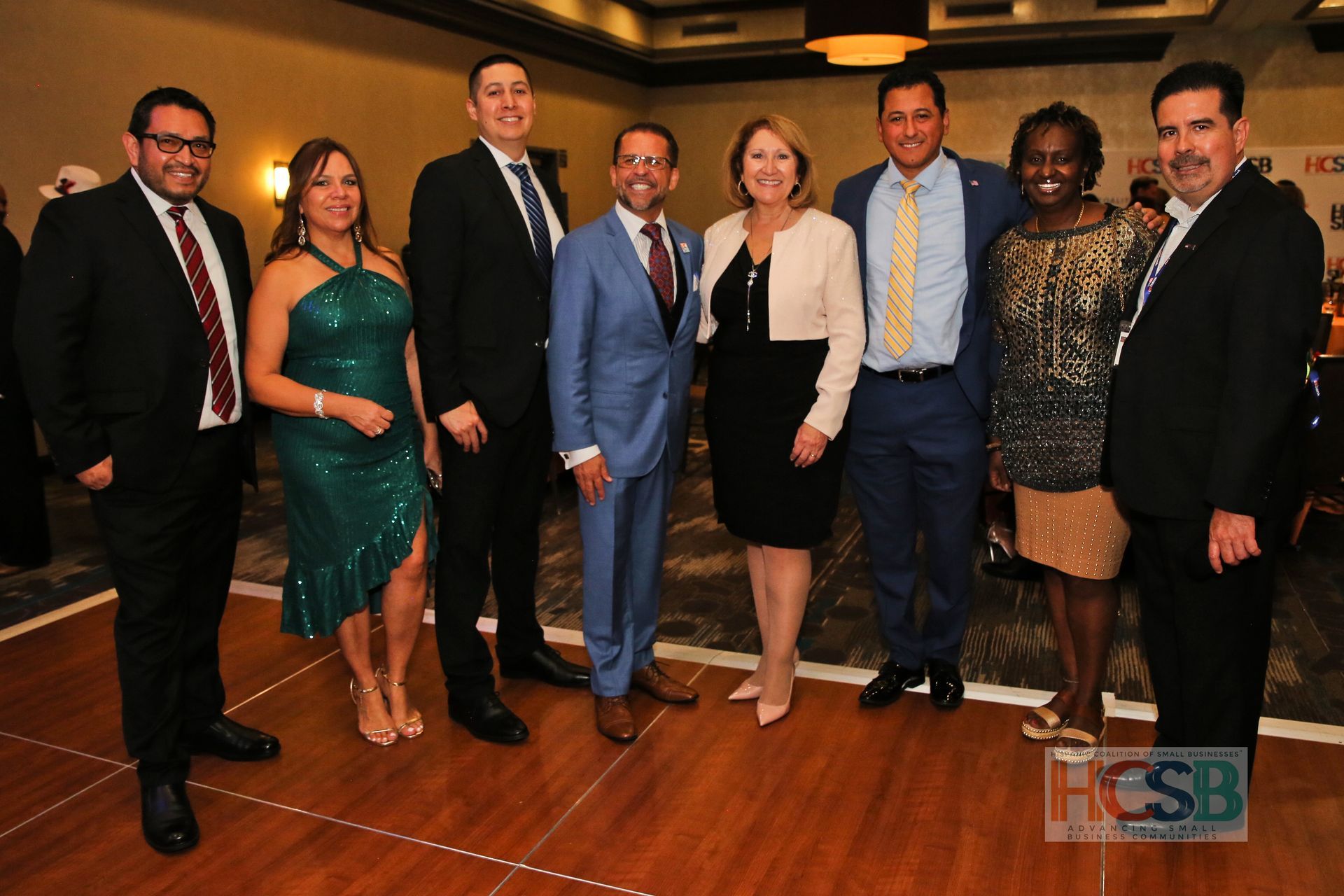 A group of people posing for a picture with a hcsb logo in the corner