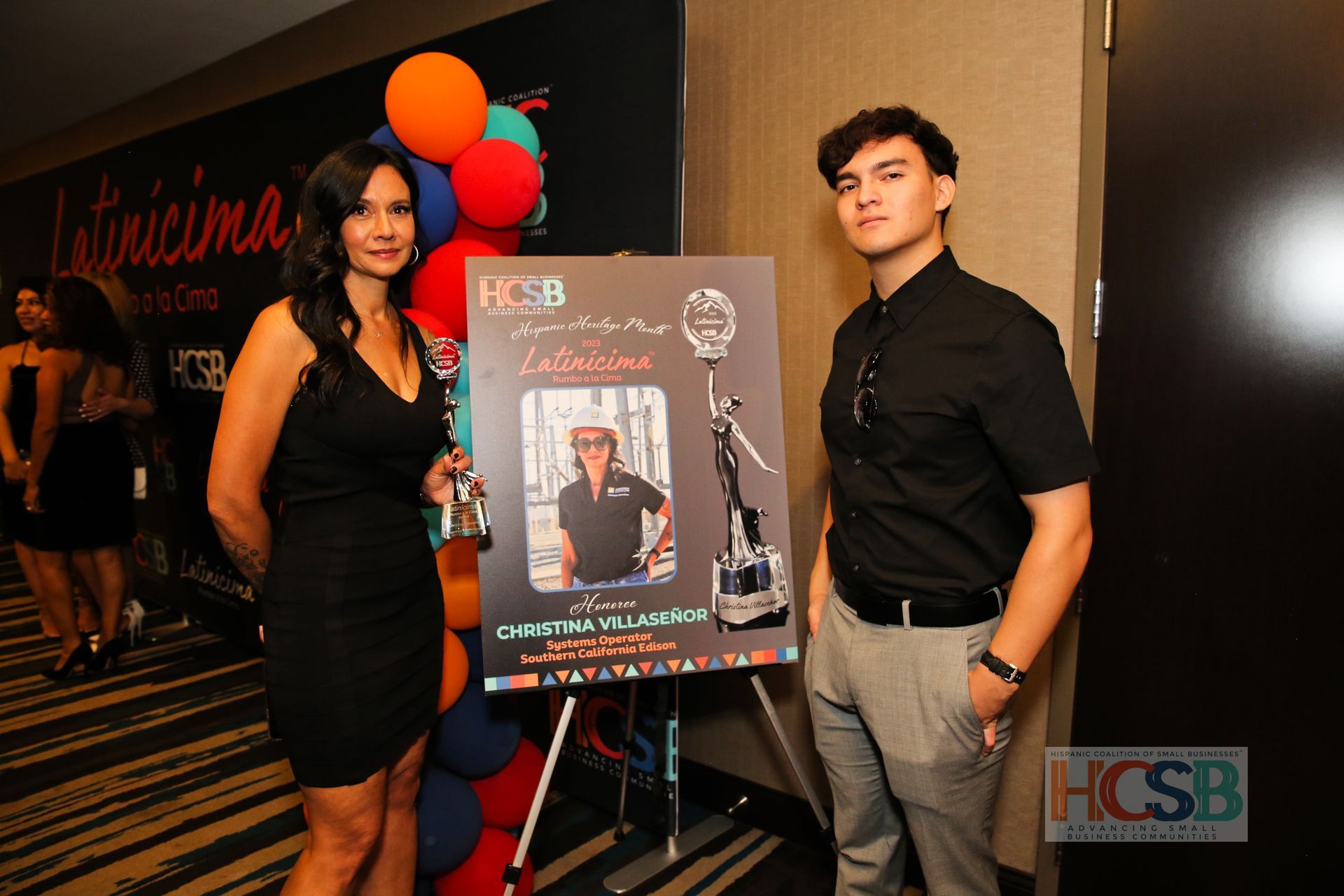 A man and a woman standing next to a sign that says hcsb