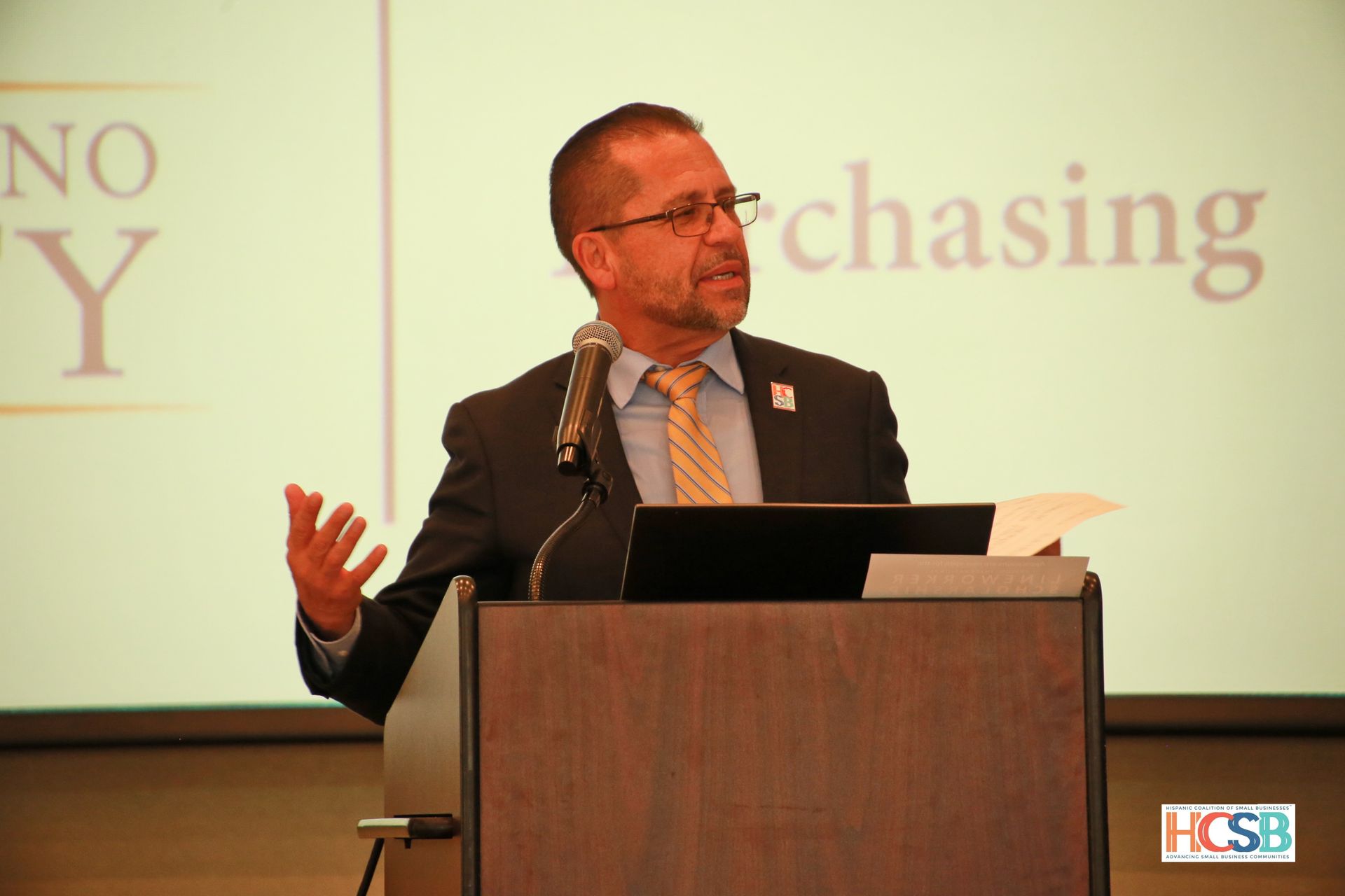 A man stands at a podium with the word chasing behind him