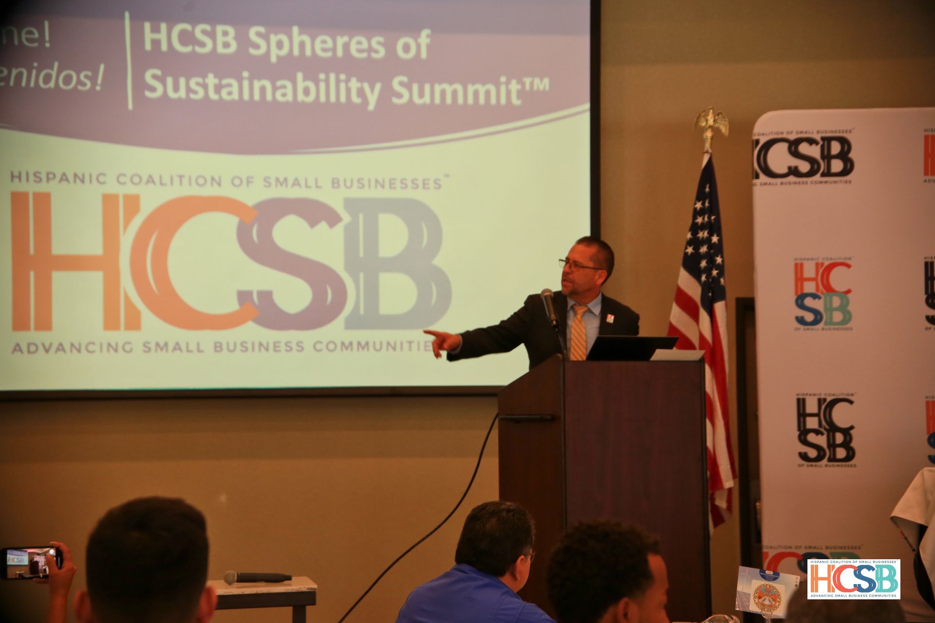 A man is giving a presentation at the hcsb spheres of sustainability summit