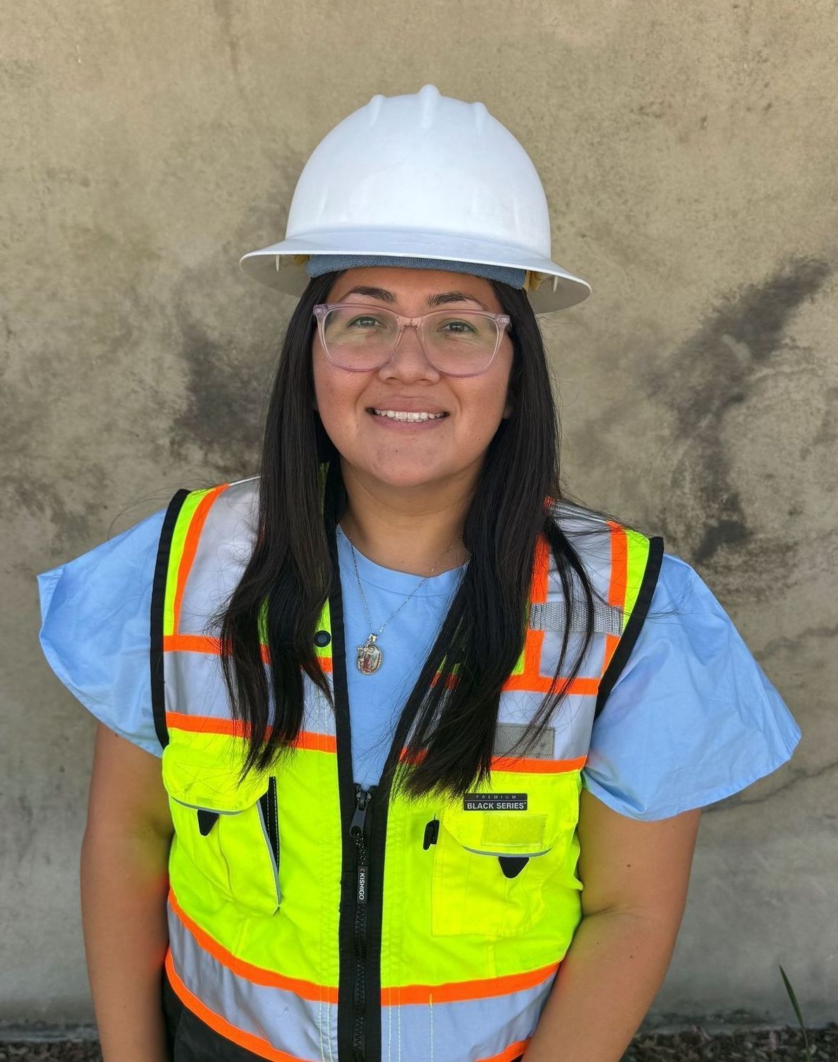 A woman wearing a hard hat and safety vest