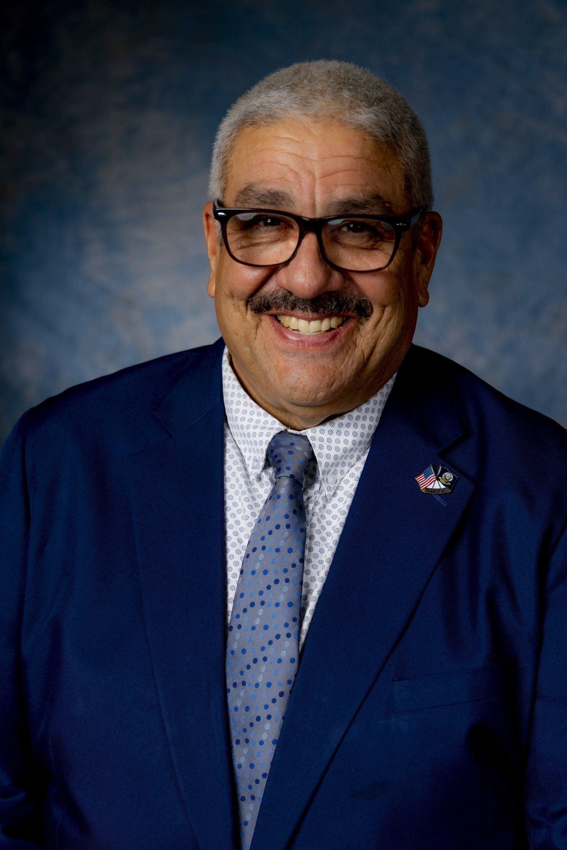 A man in a suit and tie is smiling for the camera.