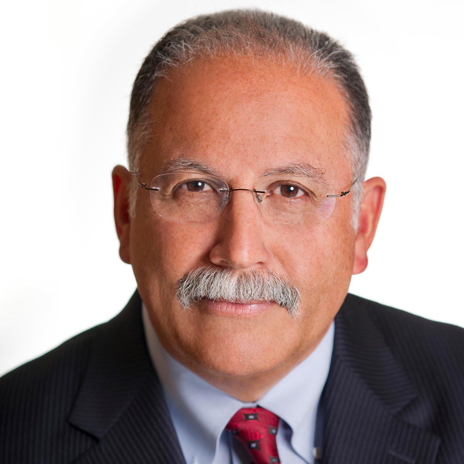 A man in a suit and tie is smiling for the camera