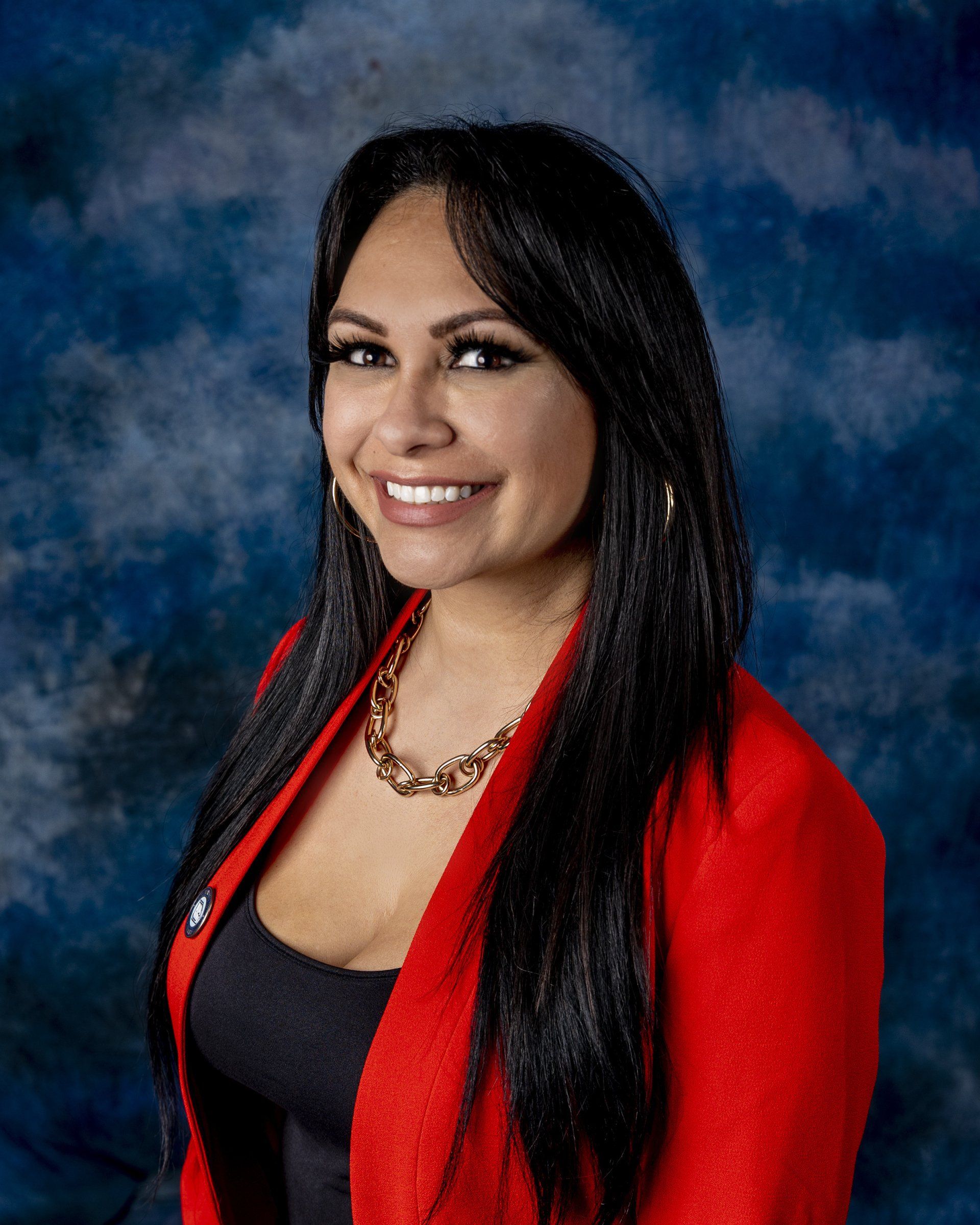 A woman wearing a red jacket and black top smiles for the camera