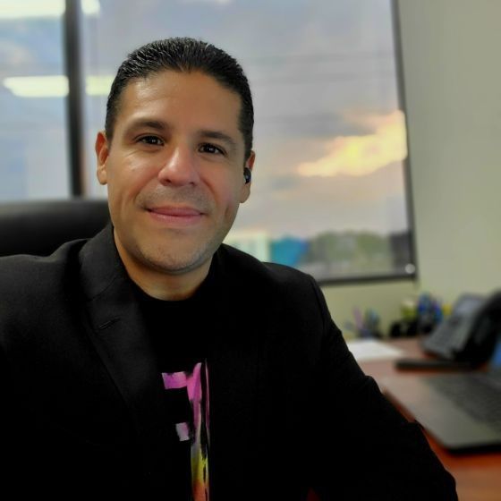 A man in a suit and tie is smiling for the camera