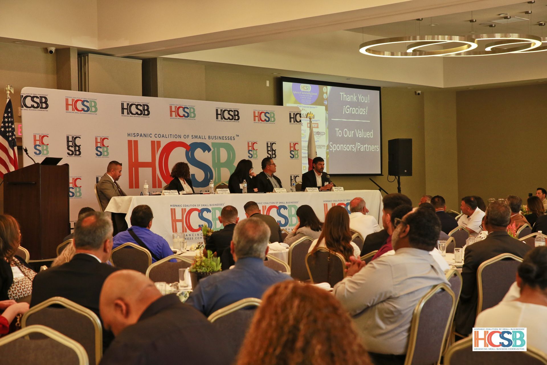 A group of people are sitting in a conference room at a hcsb conference