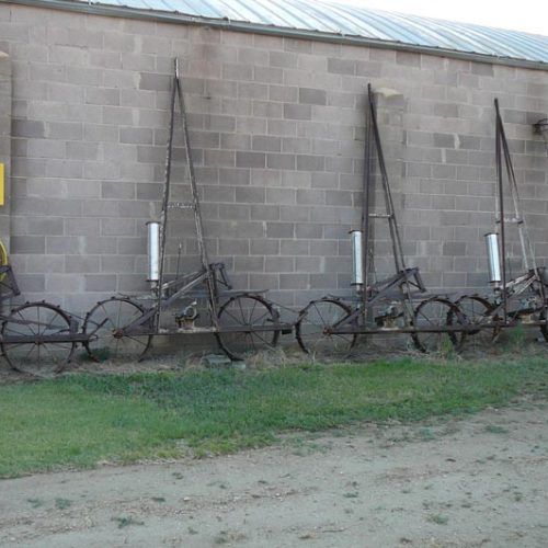 A row of bicycles are parked in front of a brick building