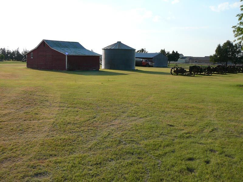 A red barn sits in the middle of a grassy field