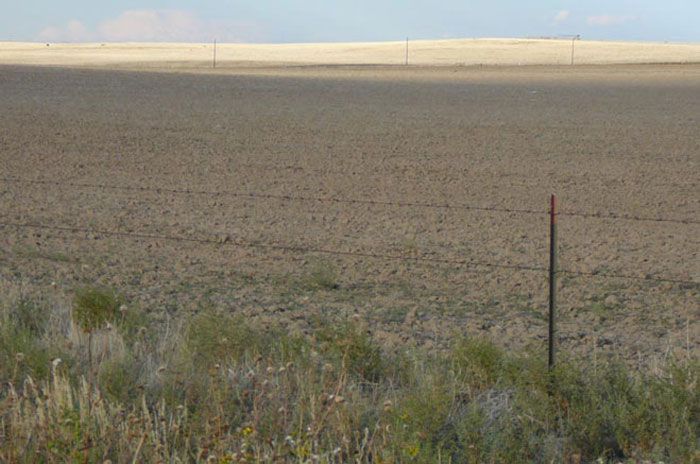 There is a fence in the middle of a field.