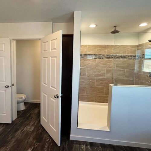 A bathroom with a walk in shower and a toilet.