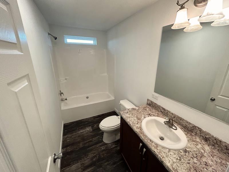 A bathroom with a toilet , sink , and bathtub.