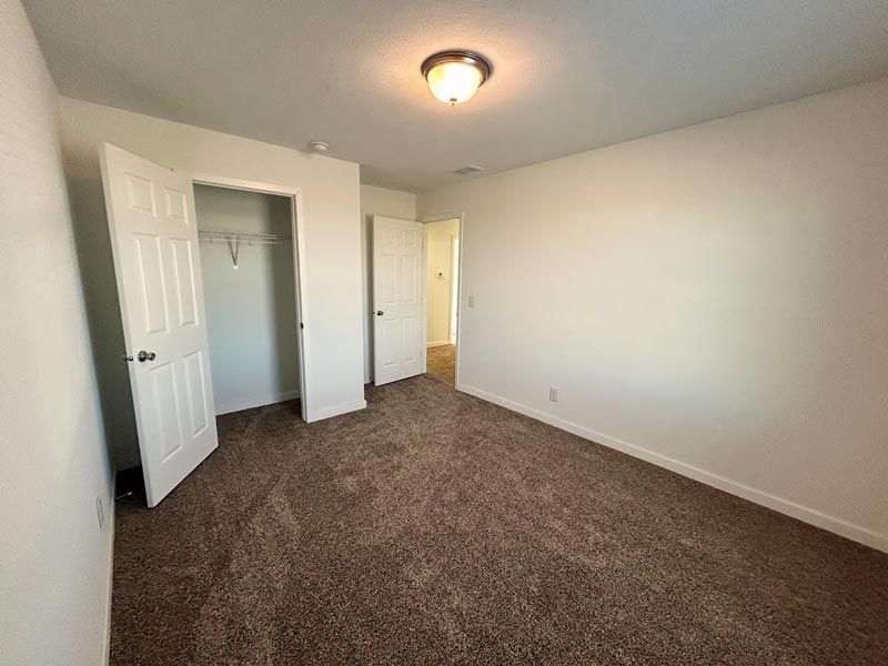 An empty bedroom with a closet and a light on the ceiling.