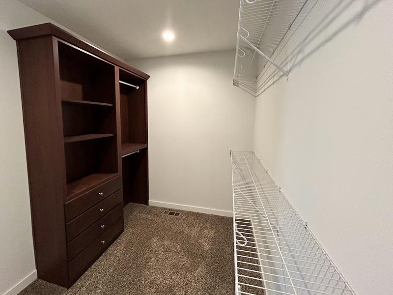 A walk in closet with lots of shelves and drawers.