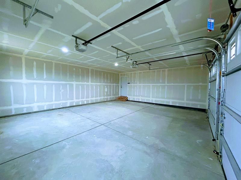 A large empty garage with a garage door open.