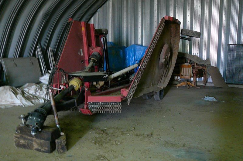 A large red machine is sitting in a warehouse.