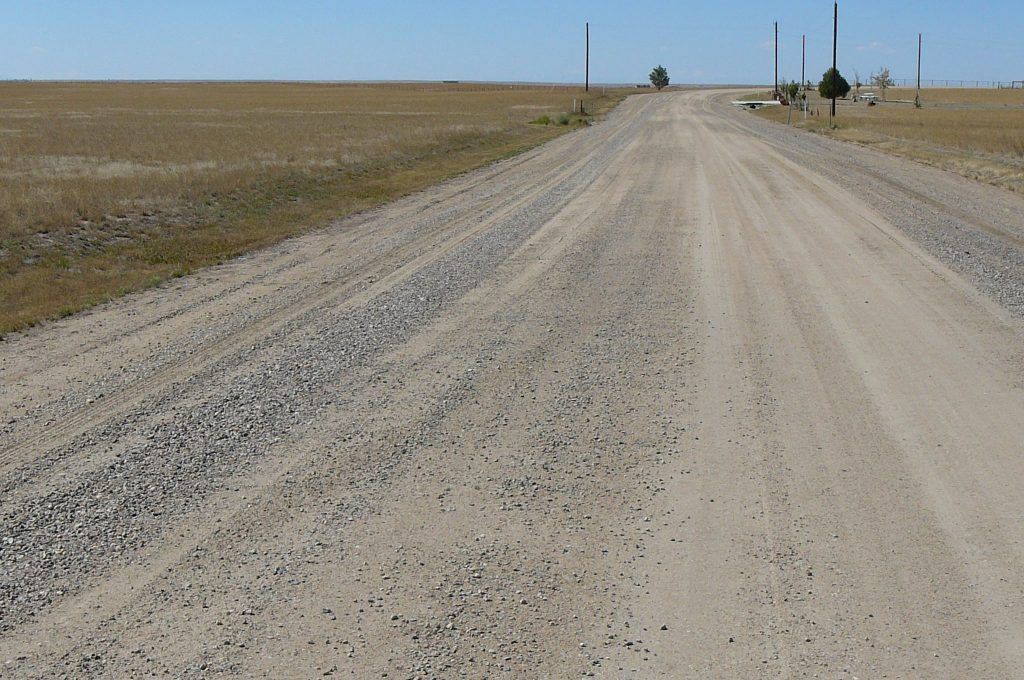 A dirt road in the middle of a field