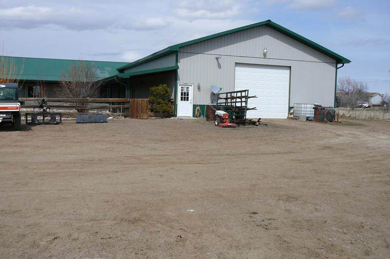 A truck is parked in front of a barn with a white garage door