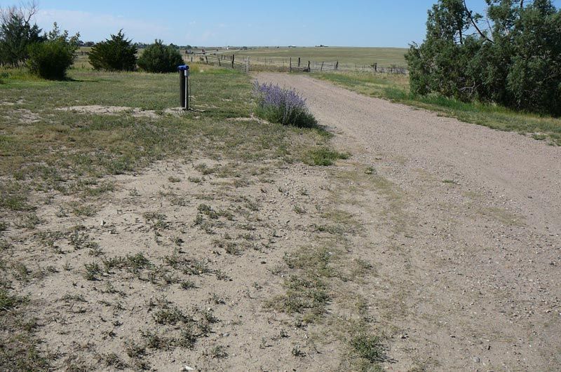 A dirt road with a mailbox on the side of it