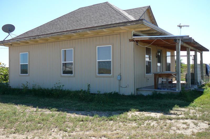 A house with a porch and satellite dish on the roof