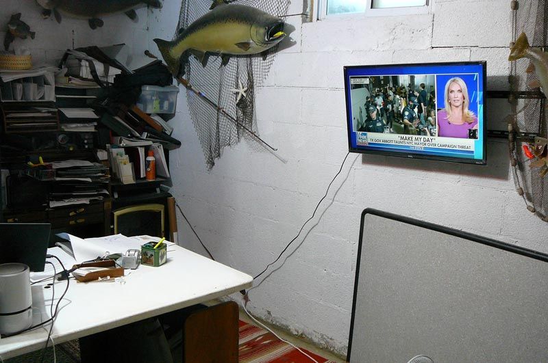 A room with a tv and a fish on the wall