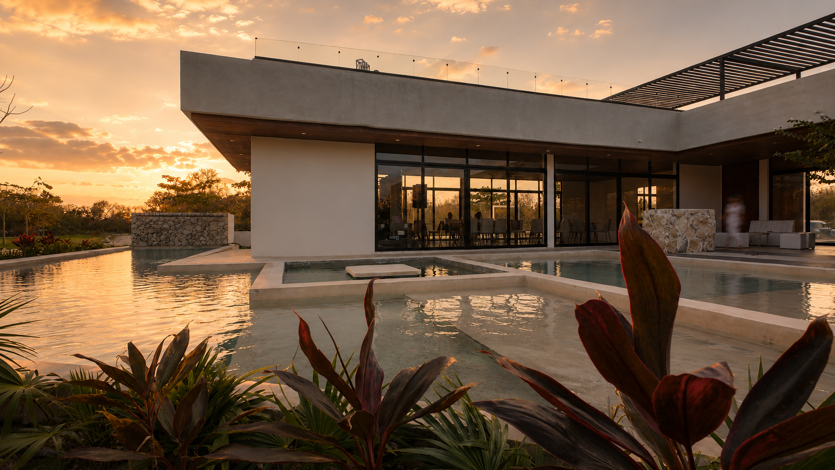 Casa club de Salama al atardecer, alberca, piedra y vegetación yucateca bañadas por la luz dorada