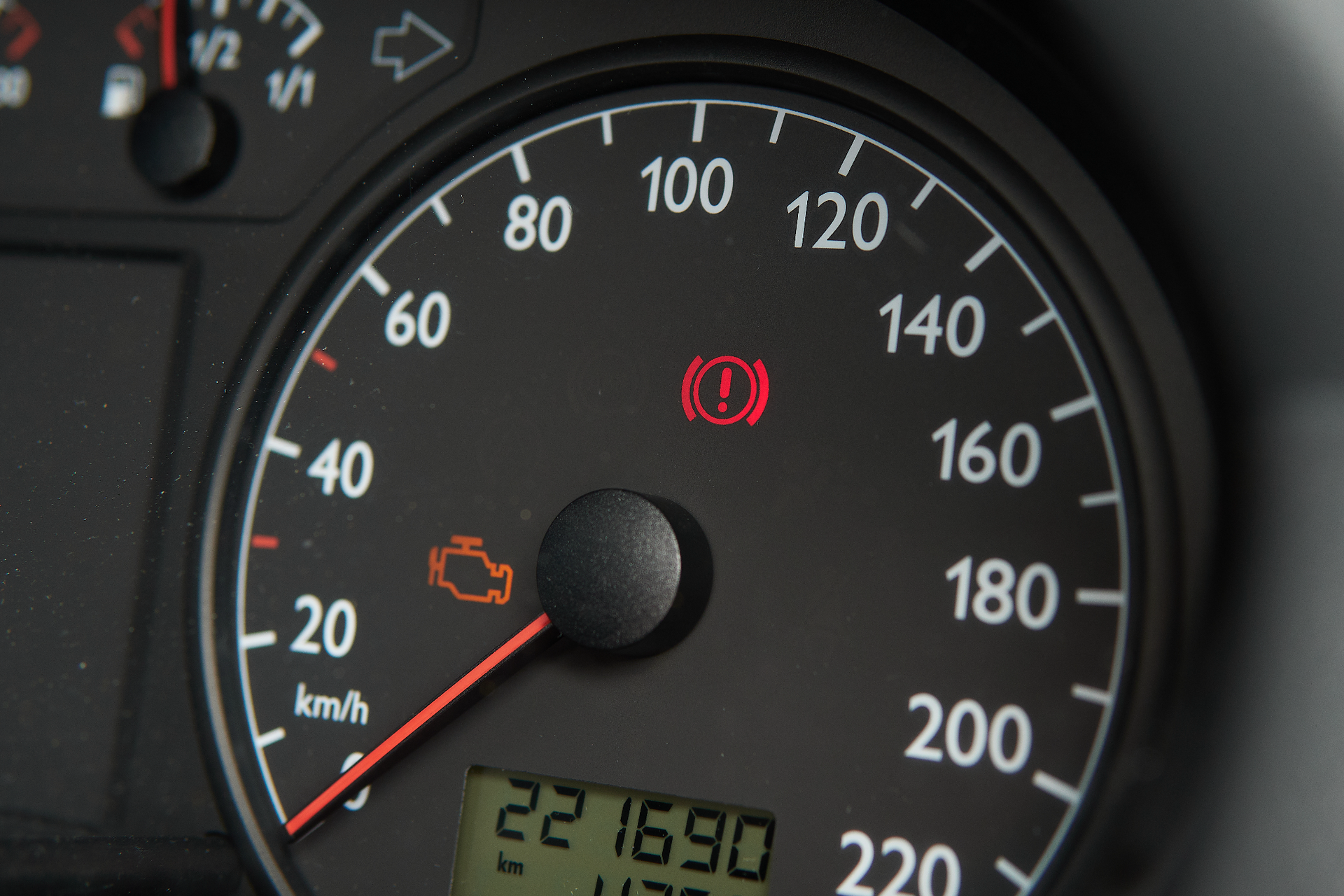 Car dashboard showing a check engine light on.