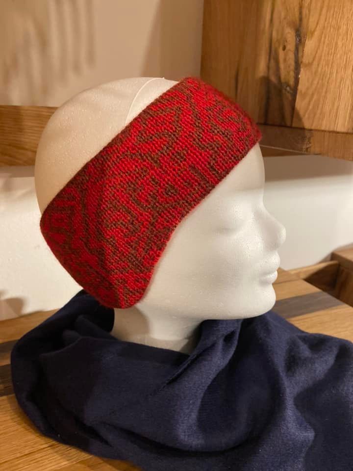 Eine Schaufensterpuppe mit einem roten Stirnband und einem blauen Schal.