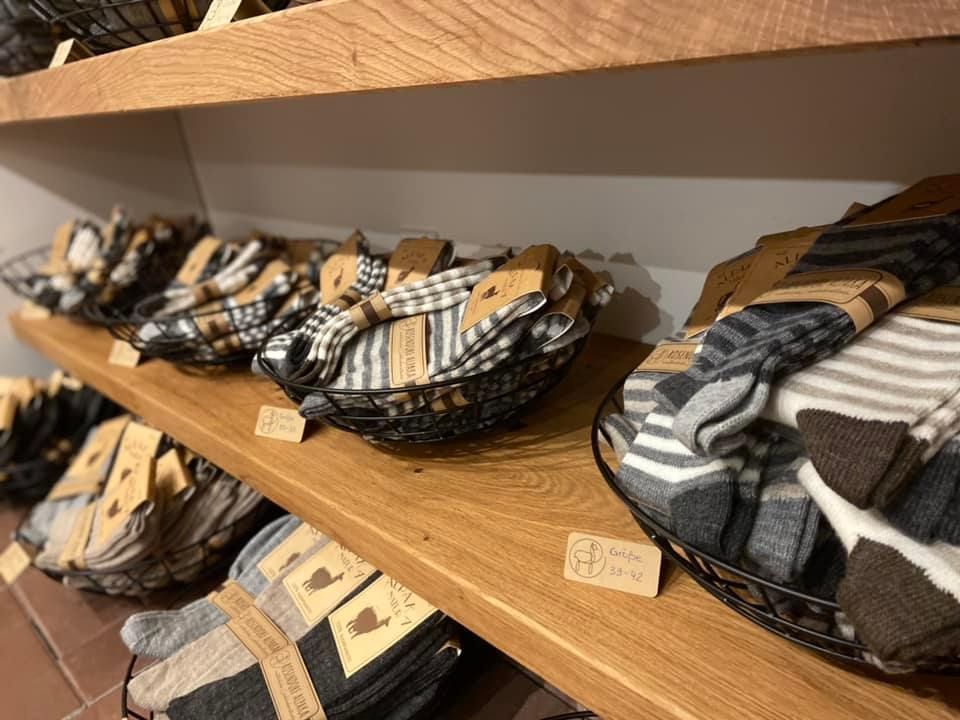 Auf einem Holzregal steht eine Reihe von Körben voller Socken.