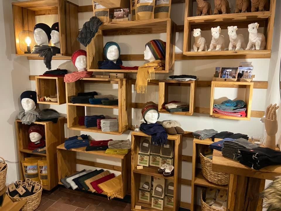 Ein Raum voller Holzregale, Kisten und Schaufensterpuppen.