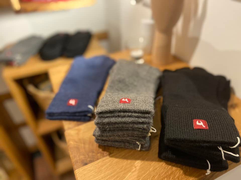 Drei Paar Socken liegen übereinander auf einem Holztisch.