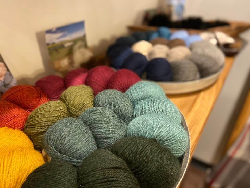 Ein Bündel Wollknäuel liegt auf einem Holztisch.