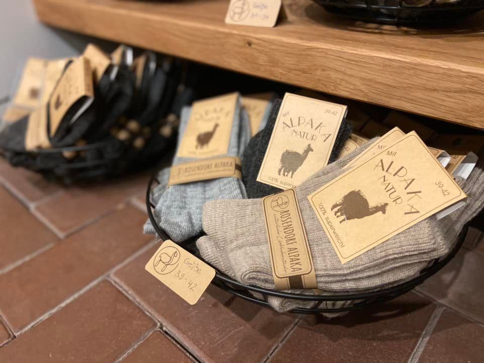 Auf einem Holzregal steht ein Korb mit Socken.