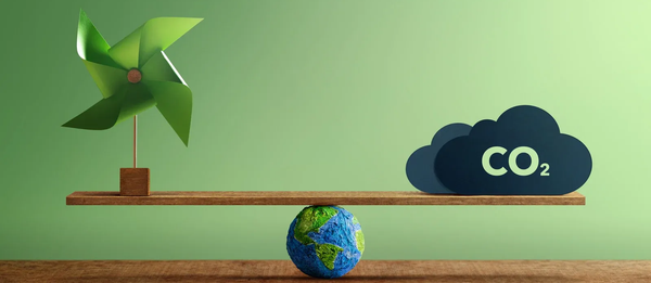 A balanced scale with a pinwheel on one side and CO2 on the other, supported by a globe, on a green background.