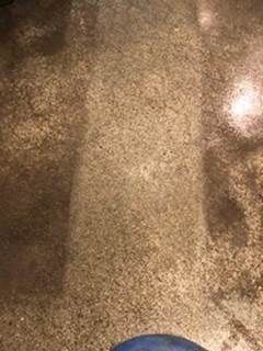 Close-up of a brown, textured surface with dark shadows and a small bright reflection on the right.
