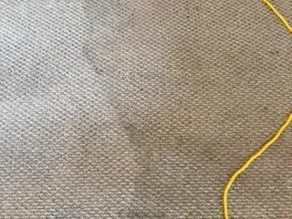 Close-up of light gray woven fabric with a yellow cord along the edge.