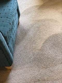Blue upholstered chair beside a beige carpet with a curved shadow