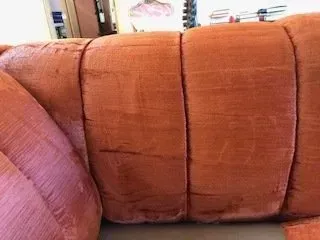 Orange and pink couch cushions with visible seams and textured fabric
