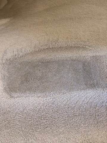 Close-up of a beige textured fabric with a rectangular darker patch in the center