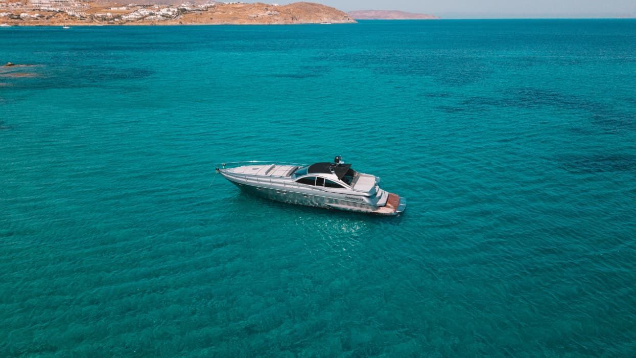 Luxury motor yacht cruising in turquoise waters for a private charter in Mykonos