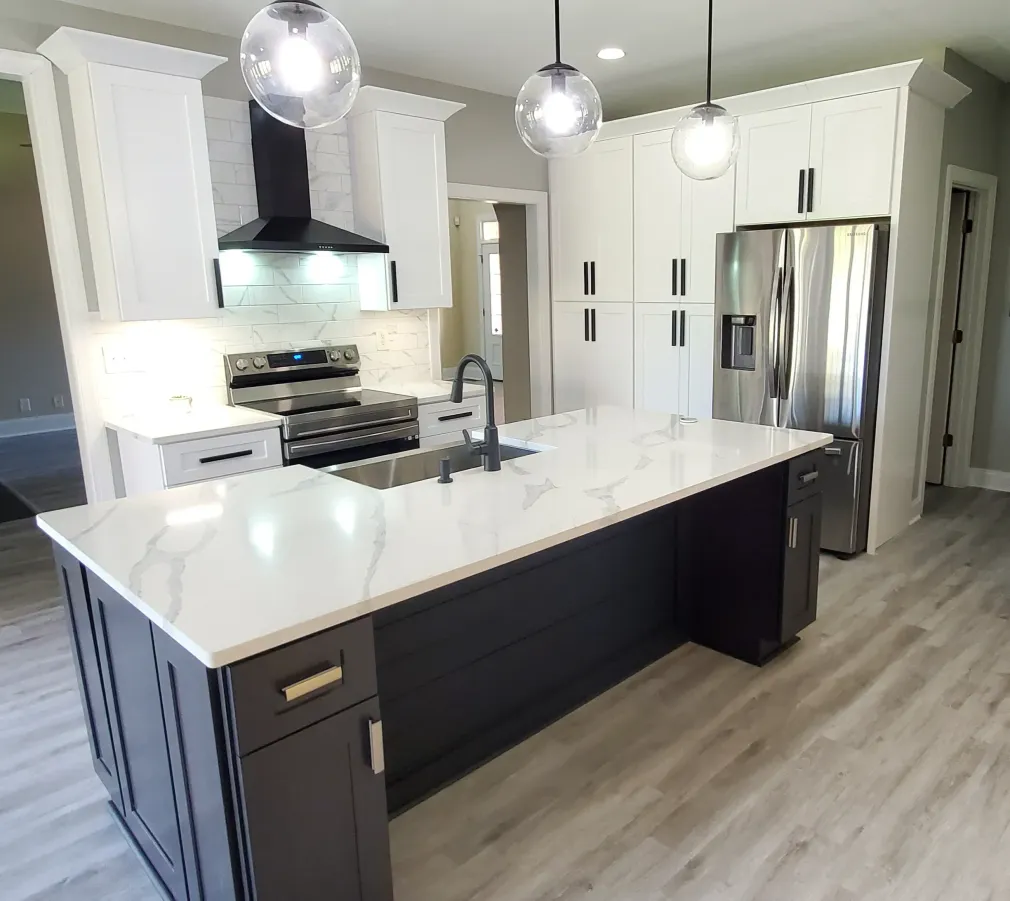 A kitchen featuring a dark blue island with a white countertop, stainless steel appliances, and white cabinets.