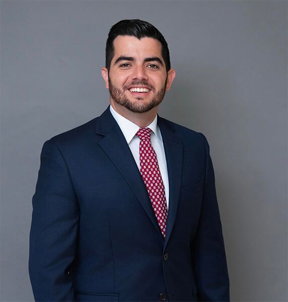 A man in a suit and tie is smiling for the camera.