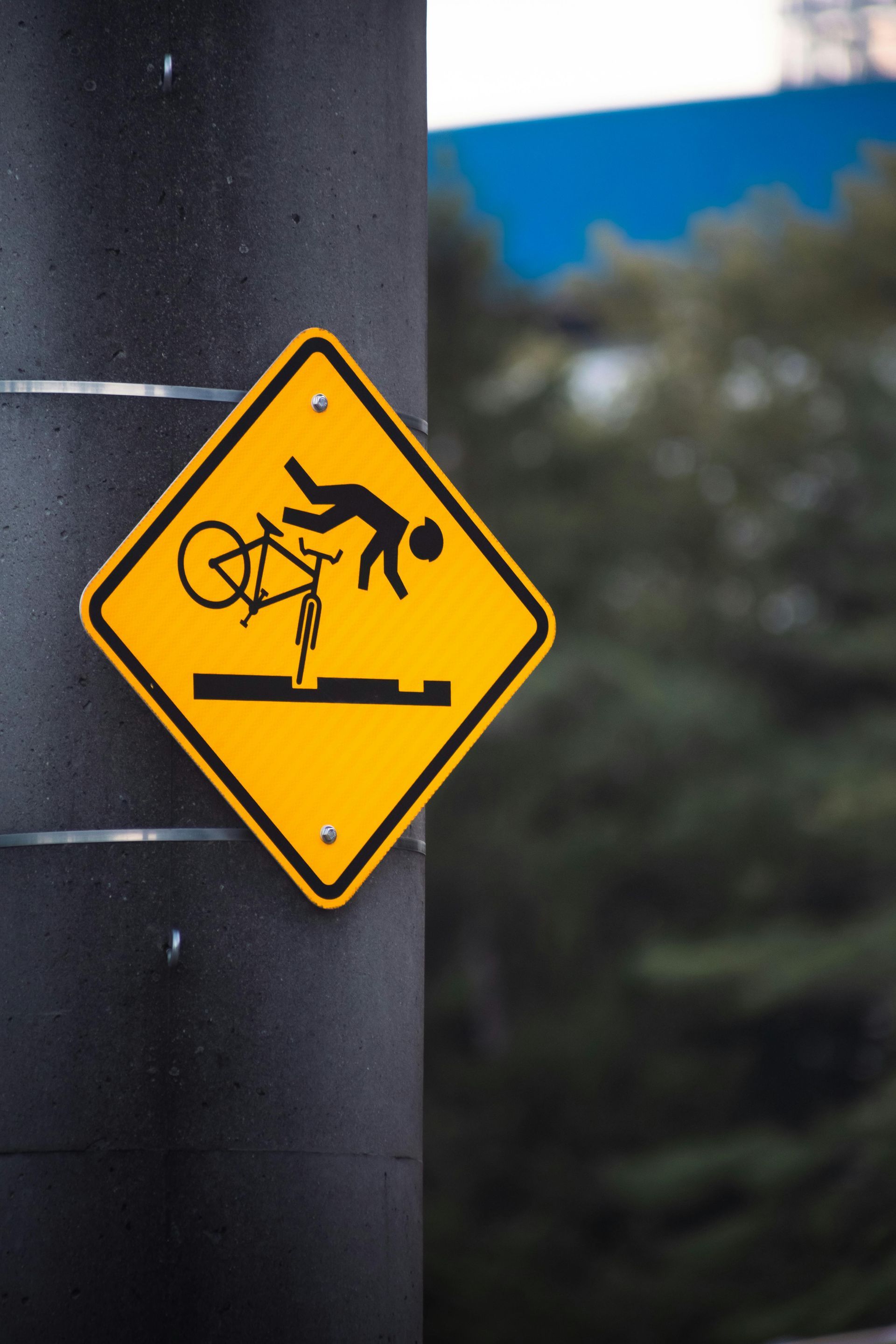 A yellow sign shows a person falling off a bike
